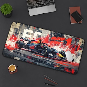 May include: A rectangular mouse pad featuring a Formula 1 race car in motion, with red and black accents. The design includes the number 1 and the text "PooBull" on the car, set against a background of abstract newspaper clippings.