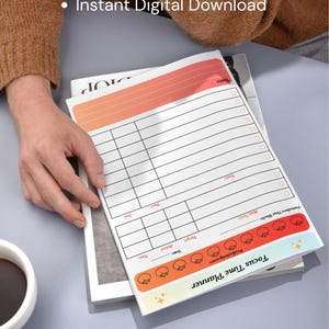 May include: A white Focus Time Planner with a gradient orange and red header and footer. The planner includes sections for notes, tasks, and time tracking. The text "What You Will Receive" and "Instant Digital Download" are also visible.