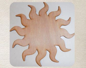May include: A wooden sun shape with a light brown color. The sun has 12 rays.