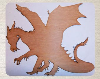 May include: A wooden cutout of a dragon with wings spread wide. The dragon is brown and has a long tail. The cutout is on a white background.