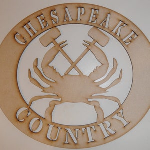 May include: A wooden sign with the words "CHESAPEAKE COUNTRY" in a circle around a silhouette of a crab with two crossed crab mallets.