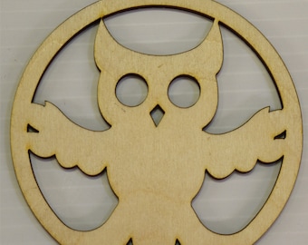 May include: A wooden owl ornament with a circular shape and a hole at the top for hanging. The owl is cut out of the wood, creating a silhouette effect.
