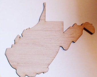 May include: A wooden cutout of the state of West Virginia. The cutout is made of light brown wood and has a smooth, unfinished surface.