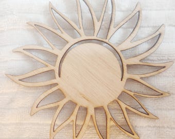 May include: A wooden sun cutout with a circular opening in the center. The sun has a simple design with rays extending from the center.