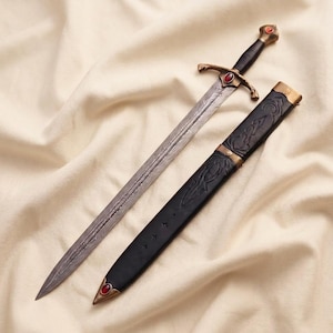 May include: A double-edged sword with a patterned steel blade, a black grip, and a bronze-toned crossguard featuring a central red stone. The matching black scabbard includes bronze-toned accents and a red stone at the pointed tip.