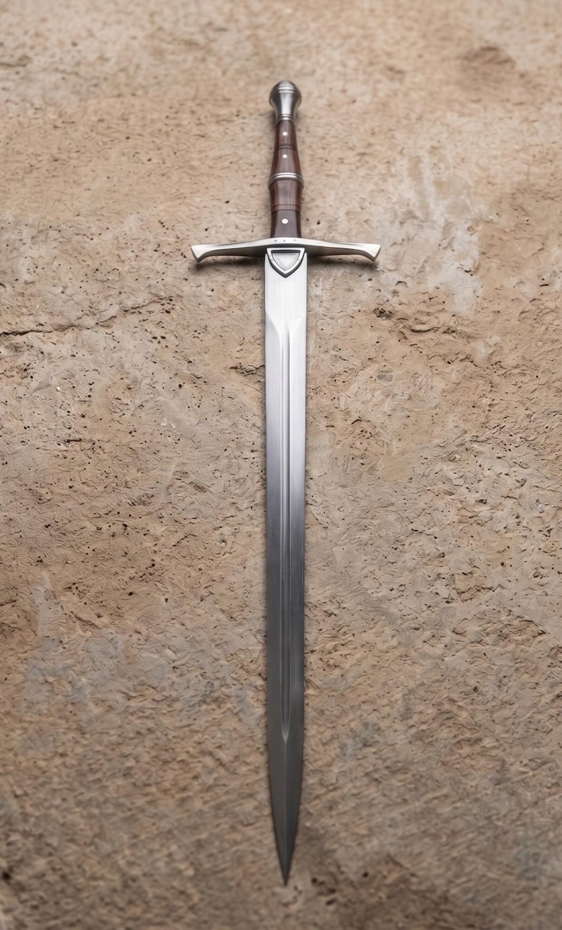 May include: A long, silver sword with a brown handle and a crossguard. The blade is straight and tapers to a point. The sword is set against a textured, tan background.
