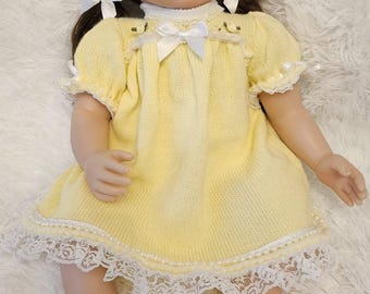 Vestido de bebé de punto color amarillo limón con ribete de encaje para muñecas de 22/24 pulgadas.