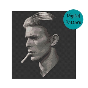 May include: Black and white cross-stitch pattern of a man with short, dark hair, wearing a dark shirt, and holding a cigarette in his mouth. The man is looking to the side.