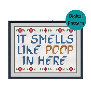 Peut inclure: Un motif de point de croix avec un fond blanc et du texte bleu, orange et rouge qui dit "It smells like poop in here". Le texte est entouré d'une bordure de fleurs rouges et vertes.
