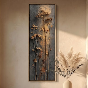 May include: A vertical rectangular wall art piece featuring dried brown botanical stems and flower heads arranged against a textured dark gray and golden-brown background, all enclosed within a simple light-colored wooden frame.