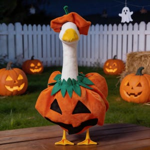 May include: A plush goose wearing a Halloween pumpkin costume, complete with a matching hat. The goose stands on a wooden surface, with carved jack-o'-lanterns and a white picket fence in the background. A festive Halloween decoration.