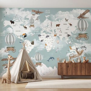 May include: A whimsical children's room scene featuring a world map wallpaper with animal illustrations and vintage airships. A teepee, giraffe, and wooden cabinet complete the playful decor. The map includes the text "PACIFIC OCEAN", "ATLANTIC OCEAN", "ARCTIC OCEAN", and "INDIAN OCEAN".