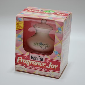 May include: A pink ceramic jar with a floral design and a lid. The jar is labeled "Renuzit Fragrance Jar Floral Potpourri 0.23 fl.oz. CAUTION: EYE IRRITANT"