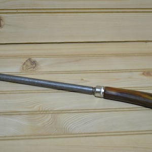 May include: A metal knife sharpener with a brown and black handle. The sharpener is made of metal and has a silver band around the handle.