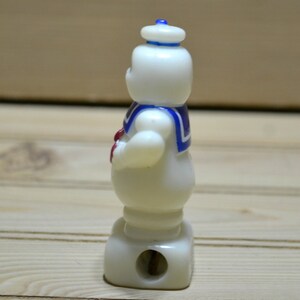 Puede incluir: Sacapuntas de pl&aacute;stico blanco con forma del personaje de los Cazafantasmas, el Stay Puft Marshmallow Man. El sacapuntas tiene un gorro de marinero azul y blanco y una corbata de lazo roja.