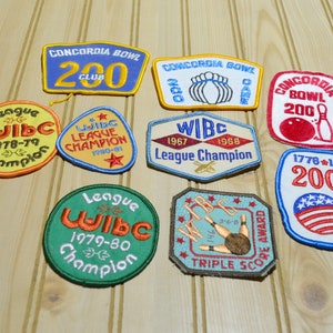 May include: Nine embroidered patches with various designs related to bowling. The patches feature the text "WIBC", "Concordia Bowl", "League Champion", "200", "Triple Score Award", and "1776-1976".