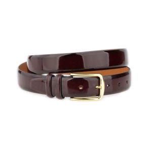 May include: A glossy, burgundy leather belt with a gold-colored rectangular buckle. The belt is rolled up, showcasing its polished finish and classic design. The belt is a versatile accessory.