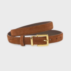 Könnte beinhalten: Ein brauner Wildleder-Gürtel mit einer goldfarbenen rechteckigen Schnalle. Der Gürtel hat eine mittelbraune Farbe und scheint aus Wildleder zu sein. Die Schnalle ist goldfarben glänzend und hat eine klassische rechteckige Form.