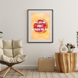 Könnte beinhalten: Gerahmter Kunstdruck mit einer Aquarellillustration einer halbierten Grapefruit. Der Text "EAT ME OUT DONT STRESS ME OUT" ist weiß. Das Kunstwerk hat eine warme, orange und rote Farbpalette.
