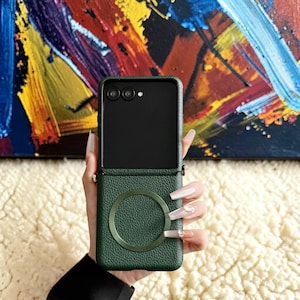 Peut inclure: Un étui de téléphone vert foncé avec un accent circulaire, conçu pour un téléphone pliable. L'étui a un aspect texturé semblable à du cuir et un anneau vert assorti. L'écran noir du téléphone est visible.