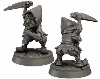 May include: Two grey unpainted miniature figurines of a hooded character in a dynamic pose. The figure wears a tunic, rope belt, and pointed shoes, holding a large blade overhead with one hand while gripping a handle with the other.