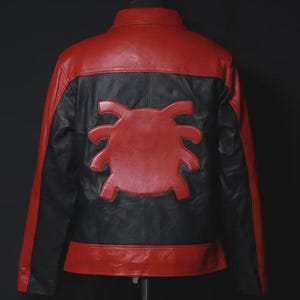 May include: A red and black leather jacket with a distinctive spider emblem on the back. The jacket features a red upper back and lower hem, with black panels and a red spider design. The jacket is displayed on a mannequin.