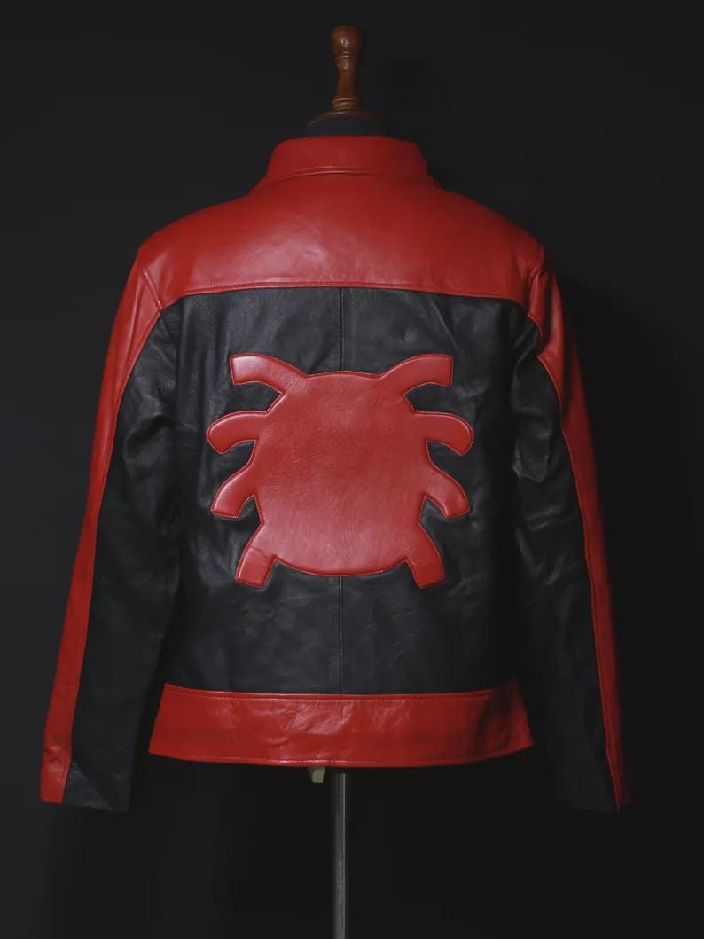 May include: A red and black leather jacket with a distinctive spider emblem on the back. The jacket features a red upper back and lower hem, with black panels and a red spider design. The jacket is displayed on a mannequin.