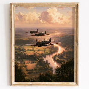 May include: A framed art print depicting three vintage propeller airplanes flying in formation over a winding river and green landscape at sunset. The sky is filled with soft, golden clouds, and the scene is enclosed in a light-colored wooden frame.