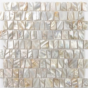 May include: A rectangular mosaic tile sheet composed of numerous small, iridescent mother-of-pearl pieces. Each individual tile has a trapezoidal shape with a smooth, reflective surface displaying natural white, cream, and silver color variations.