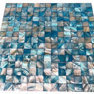 May include: A square mosaic tile sheet composed of small, individual square pieces of iridescent mother-of-pearl. The tiles feature a repeating pattern of vibrant turquoise blue and soft, pearlescent white tones with a natural, glossy finish.
