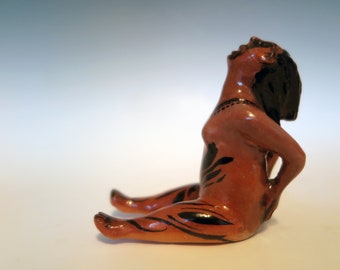 Hand carved ceramic figurine of a seated woman with head back