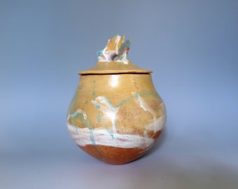 Hand modeled coiled and pinched ceramic vessel with yellow and white terra sigillata glaze