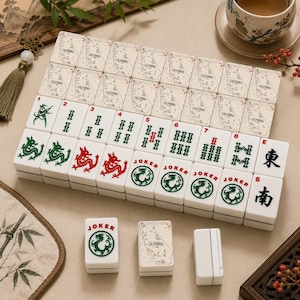 May include: A set of white Mahjong tiles featuring various designs including green and red dragons, numbered bamboo suits, Joker tiles with dragon illustrations, and tiles printed with a map of California and the text California.