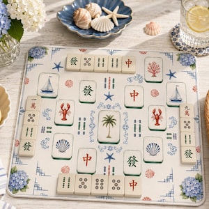 May include: A square mahjong mat featuring a coastal theme with illustrations of palm trees, sailboats, lobsters, seashells, and blue hydrangeas. The mat is arranged with various mahjong tiles displaying Chinese characters and symbols.