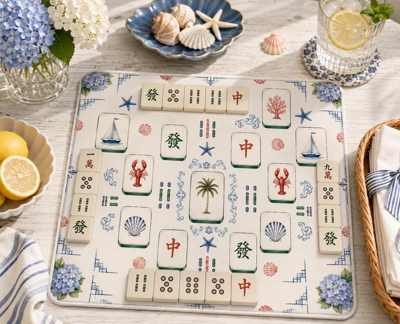 May include: A square mahjong mat featuring a coastal theme with illustrations of palm trees, sailboats, lobsters, seashells, and blue hydrangeas. The mat is arranged with various mahjong tiles displaying Chinese characters and symbols.