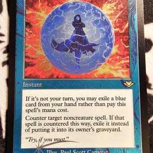 May include: A Force of Negation Magic: The Gathering trading card with a blue border and a central illustration of a figure inside a glowing blue sphere surrounded by red energy. The card text details the instant spell mechanics and flavor text.