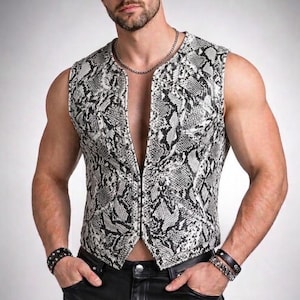 May include: A sleeveless vest featuring a black and white snakeskin pattern. The garment has a deep V-neckline, a front zipper closure, and a structured fit. The material displays a detailed reptilian scale texture throughout the entire surface.