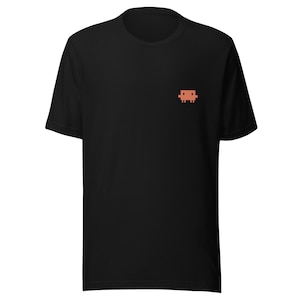 Op de afbeelding: Zwart t-shirt met een klein, gepixeld, oranjebruin bankontwerp op de linkerbovenborst. Het shirt heeft korte mouwen en een ronde hals. De stof ziet er zacht en comfortabel uit.