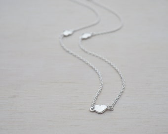 May include: A silver necklace with a delicate chain and a small heart pendant.