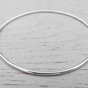May include: A simple silver bangle bracelet, a classic and timeless piece of jewelry.