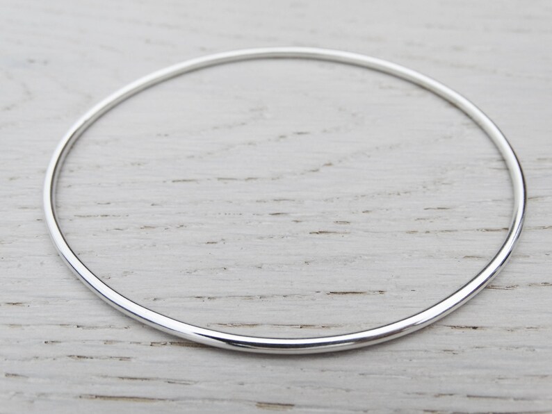 May include: A simple silver bangle bracelet, a classic and timeless piece of jewelry.