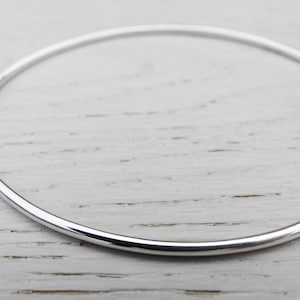 May include: A simple silver bangle bracelet, a classic and timeless piece of jewelry.