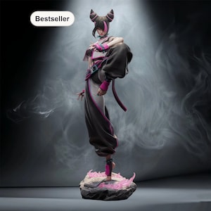 May include: A detailed figurine of a female character in a dynamic pose, with one leg raised. The figure wears a black and white outfit with pink accents. The base is a rock formation with pink flame-like details. The word "Bestseller" is in the top left corner.