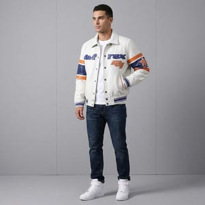 K&ouml;nnte beinhalten: Cremefarbene Collegejacke mit blauen und orangefarbenen Akzenten. Die Jacke tr&auml;gt den Text "Avirex" und "74" in blauen und orangefarbenen Buchstaben. Die &Auml;rmel haben blaue und orangefarbene Streifen. Die Person tr&auml;gt ein wei&szlig;es T-Shirt, blaue Jeans und wei&szlig;e Turnschuhe.