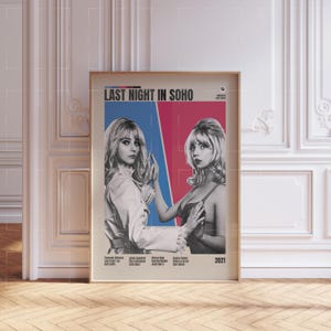 May include: A framed movie poster for "Last Night in Soho" featuring two women. The poster has a beige background with a blue and red split design. The title is at the top, and the year 2021 is at the bottom.