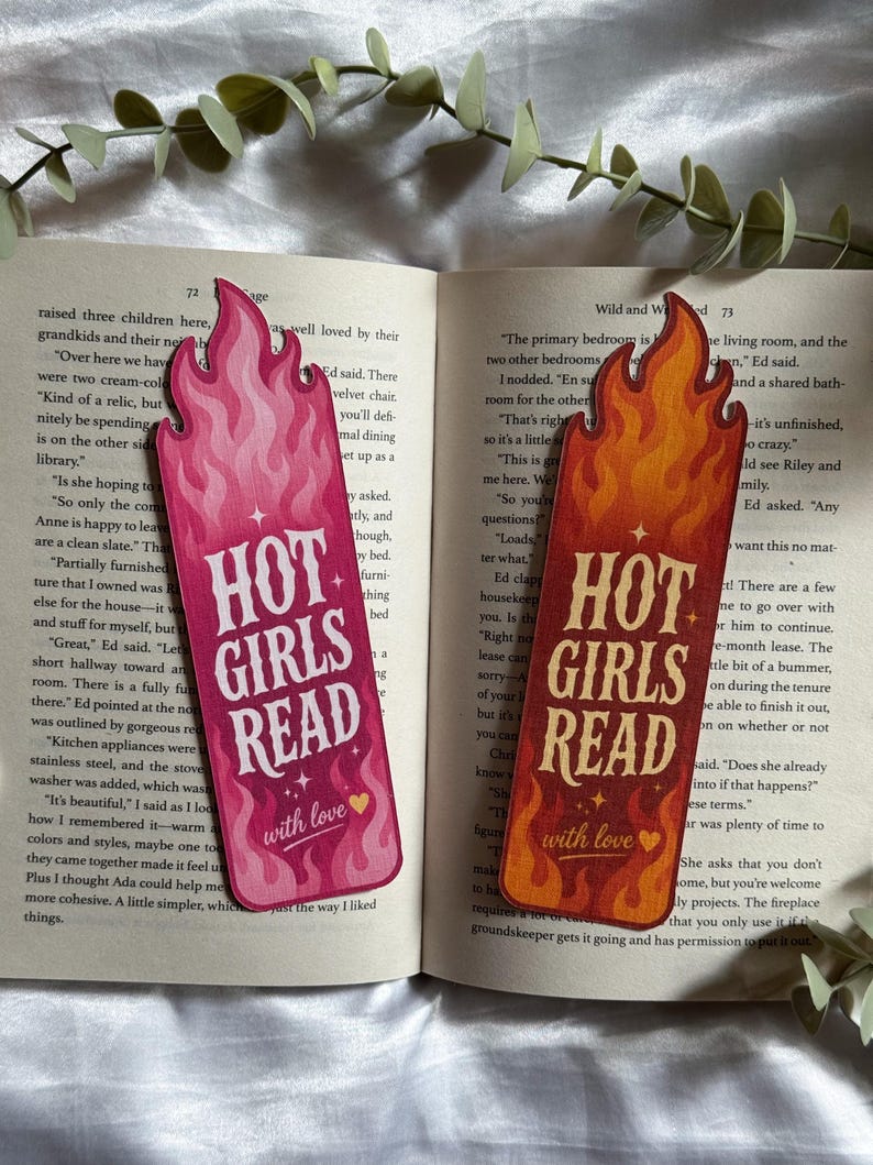 May include: Two flame-shaped bookmarks featuring the text "HOT GIRLS READ" and "with love" with a small heart icon. One bookmark is in shades of pink and magenta, while the other is in shades of orange and red, both with a stylized flame pattern.