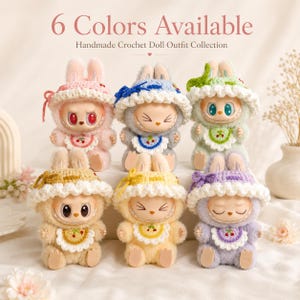 May include: Six small dolls wearing handmade crochet outfits, including hats with ruffled white brims and matching bibs with cherry motifs. The dolls are colored in pink, blue, green, beige, yellow, and purple. Text reads 6 Colors Available.