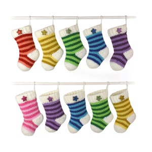 Peut inclure: Ensemble de 10 chaussettes de Noël en crochet rayées et colorées suspendues à une tringle blanche. Chaque chaussette est ornée d'une étoile blanche pailletée sur le devant.