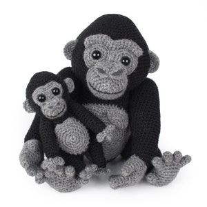 以下が含まれることがあります： 編みぐるみゴリラと、それより小さい編みぐるみベビーゴリラ。両方のゴリラはグレーとブラックで、黒い目です。