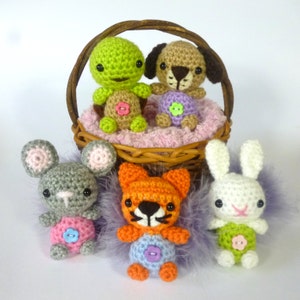 May include: Five crocheted stuffed animals in a wicker basket. The animals are a turtle, a dog, a fox, a mouse, and a rabbit. The animals are all wearing colourful clothes and have button eyes.